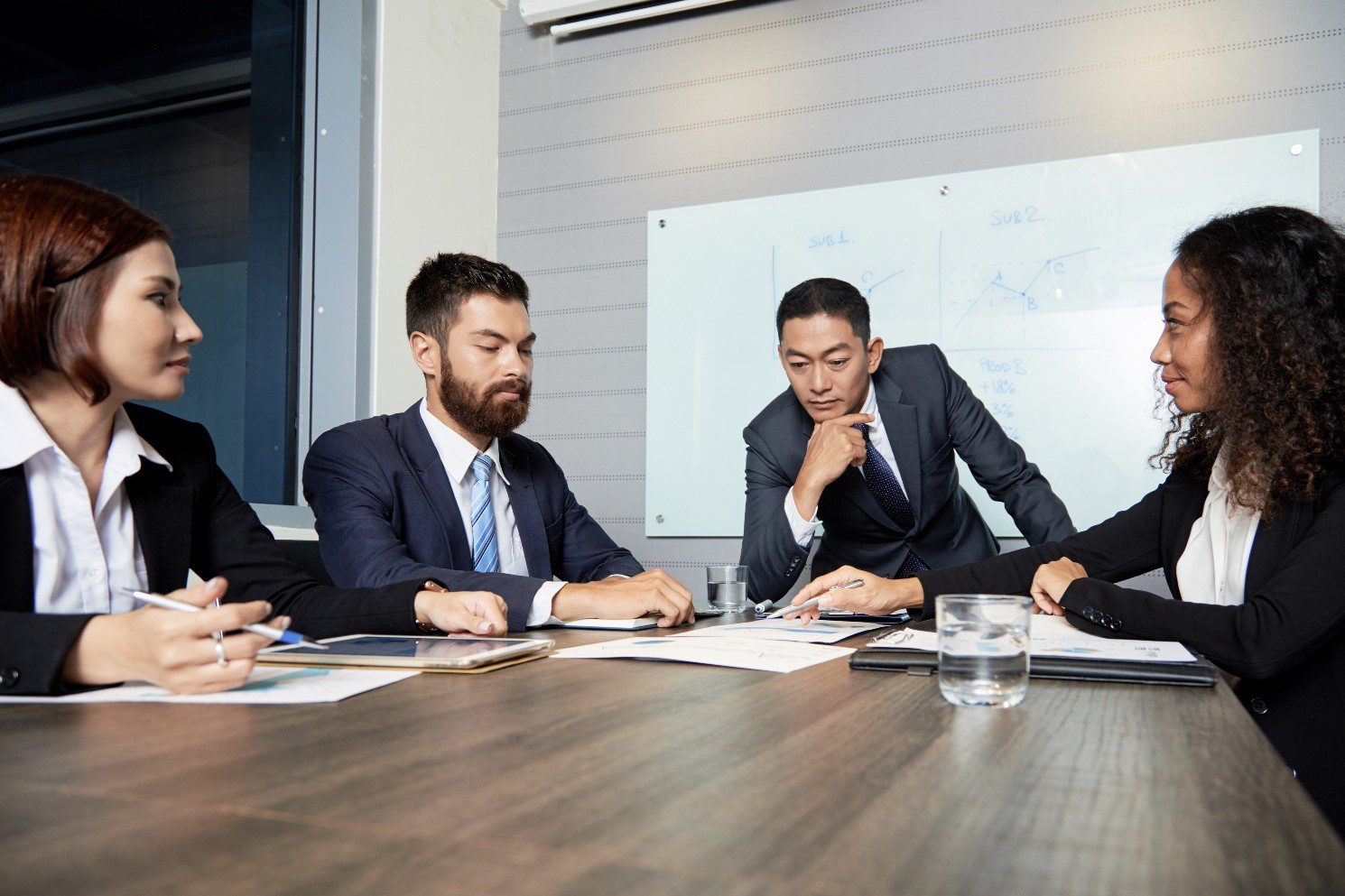 Four business professionals discussing stages of the sales cycle 
